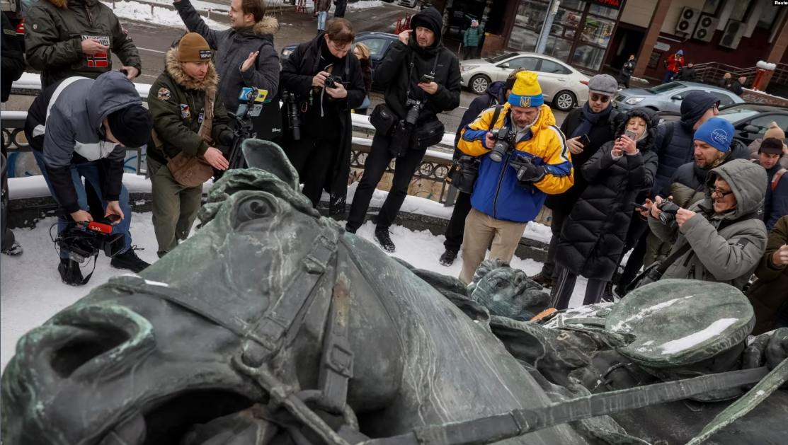 Ciudadanos observan la retirada de un monumento a Mykola Schors, un héroe soviético durante la gerra civil rusa, en las calles de Kiev, el 9 de diciembre de 2023